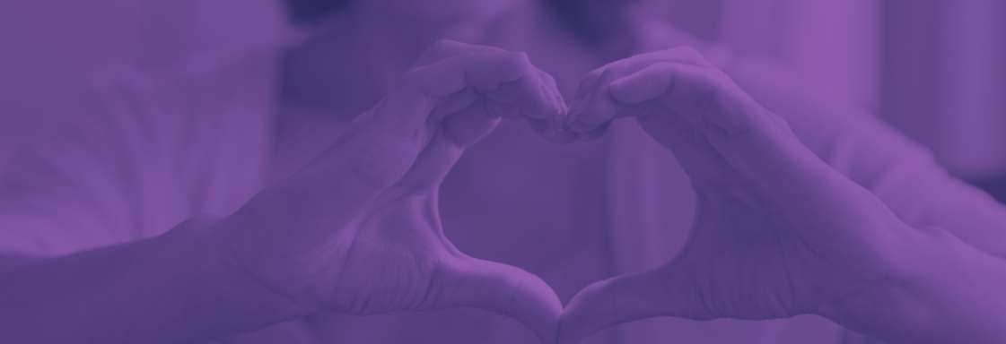 Foto de una mujer haciendo con sus manos la forma de un corazón