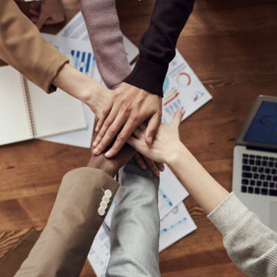 Imagen con foto en filtro morado de personas trabajando en una oficina y encima en texto en blanco que dice: Día Nacional por la Inclusión Laboral